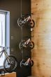 A group of three bicycles suspended from the ceiling by Loop Hangers and stainless steel cables.
