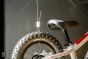 Close-up view of a stainless steel cable and Loop Hanger attached to a bicycle wheel.
