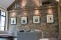 Track mounted in beam to hang art on stone wall