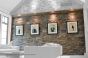 Track mounted in beam to hang art on stone wall