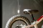 Close-up view of a stainless steel cable and Loop Hanger attached to a bicycle wheel.