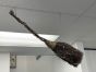 A Halloween witches' broom suspended by Drop Ceiling Hangers for T Bars.