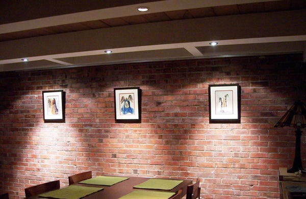 Hanging art on brick walls in a residential setting.