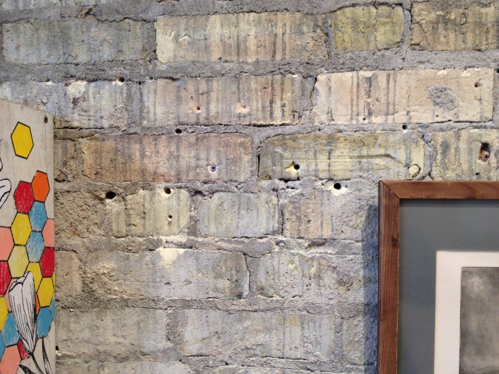 Brick wall showing excessive art display damage.