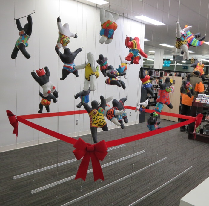 3D art display created using a tensioned cable system in multi-purpose room of public library.