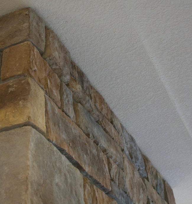 Stone fireplace with irregular front surface.  