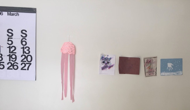 Children's arts and crafts projects taped to wall.