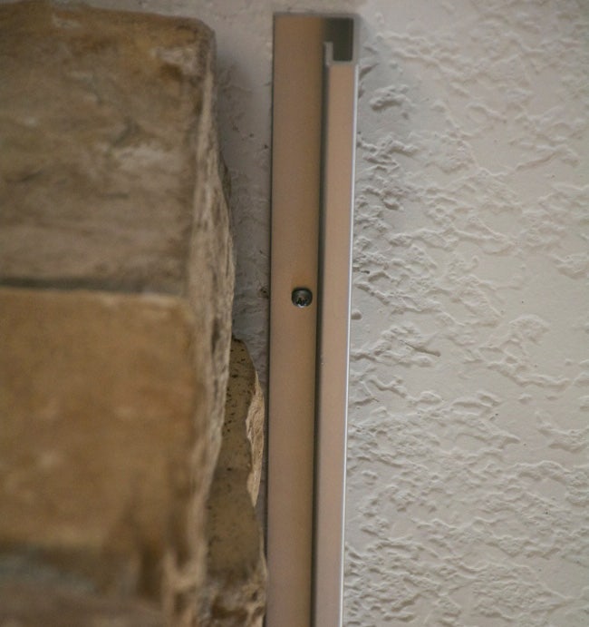 Ceiling Track mounted in closed-face orientation along stone fireplace. 