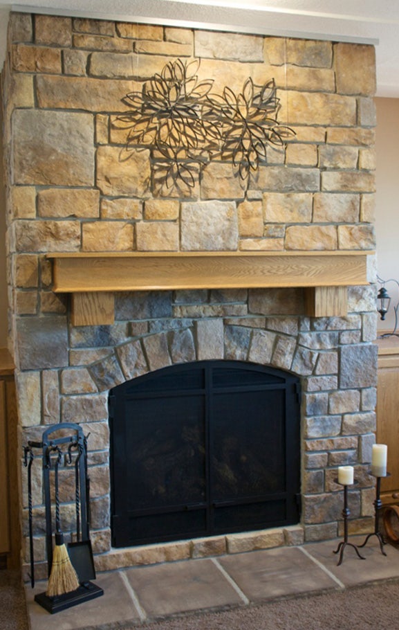 Stone fireplace with irregular surfaces using Ceiling Track as an art hanging system.